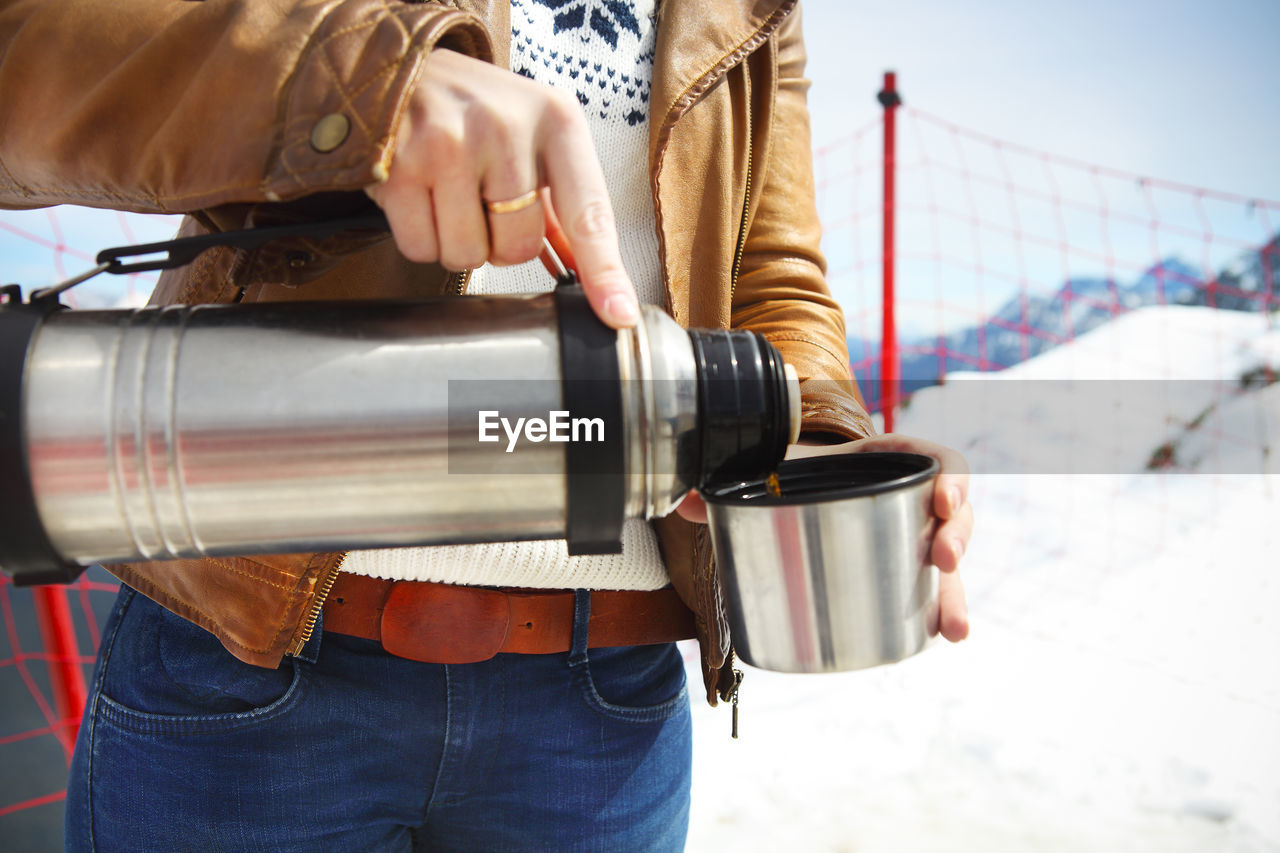 Midsection of man with coffee cup