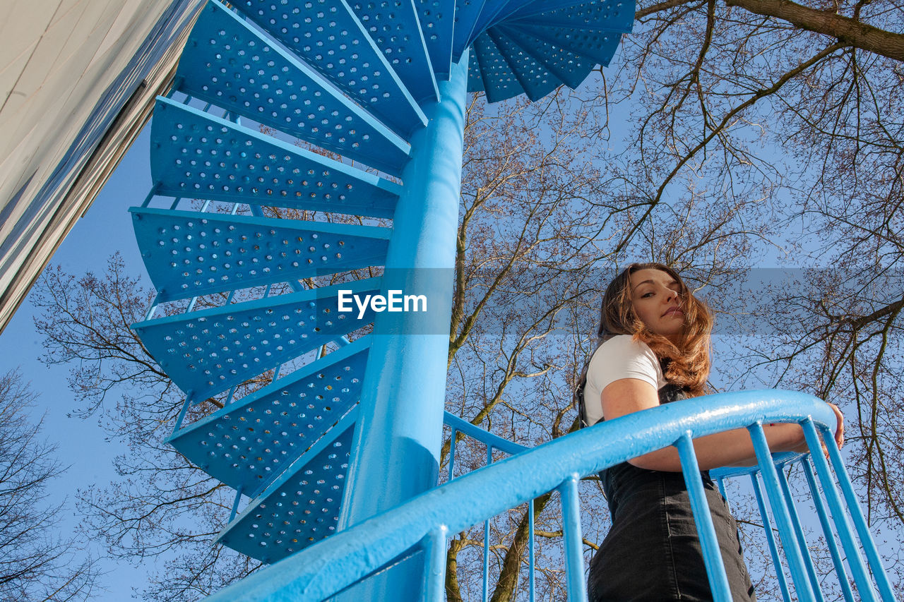 Low angle view of woman looking at blue sky