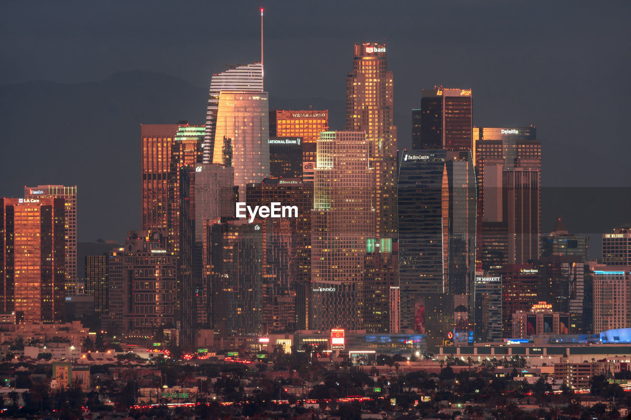 Illuminated buildings against sky at night