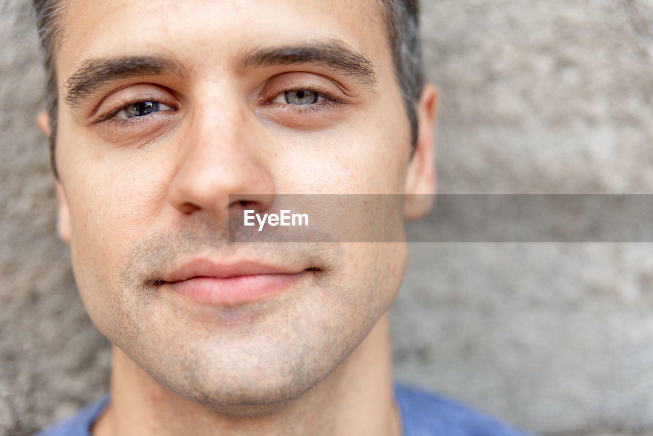 Close-up portrait of young man against wall outdoors