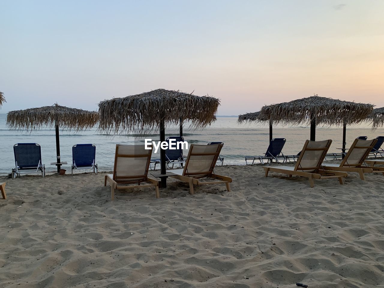 DECK CHAIRS ON BEACH AGAINST SKY AT SHORE