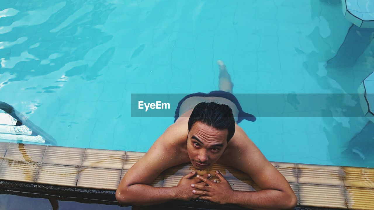 High angle portrait of shirtless man in swimming pool