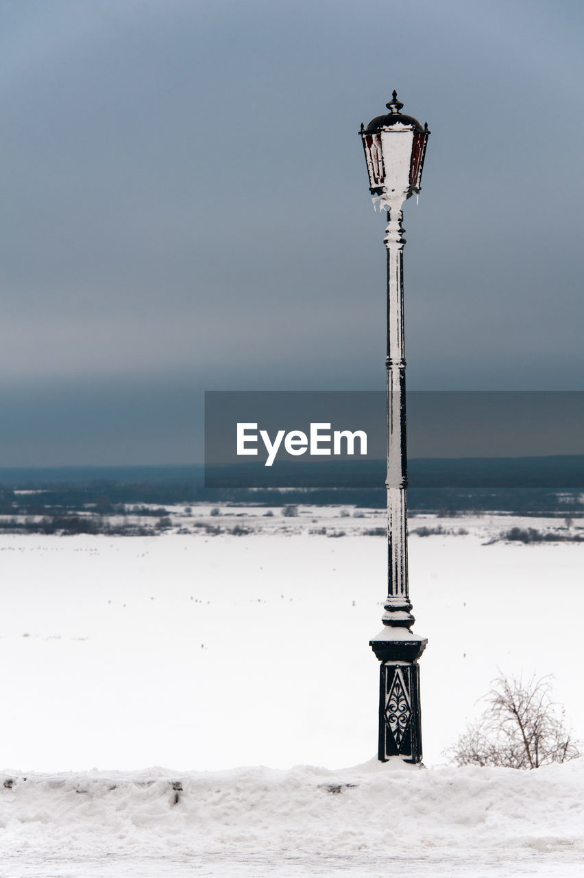 Frozen street light against clear sky