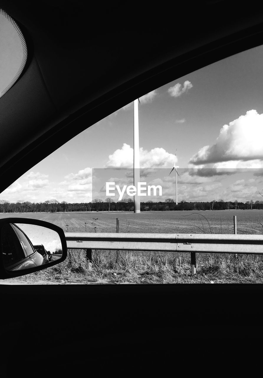 CAR ON SIDE-VIEW MIRROR AGAINST SKY SEEN THROUGH WINDOW