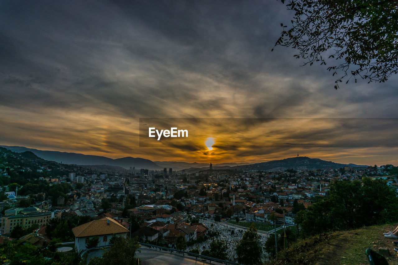 HIGH ANGLE SHOT OF TOWNSCAPE AGAINST SKY DURING SUNSET