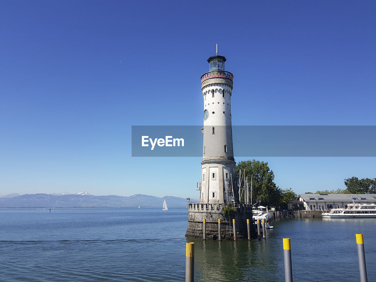 water, architecture, guidance, lighthouse, tower, built structure, building exterior, sky, building, sea, nature, security, clear sky, blue, travel destinations, protection, travel, transportation, no people, nautical vessel, day, beach, coast, outdoors, land, vehicle, scenics - nature, coastline, sunny, tourism, harbor, observation tower