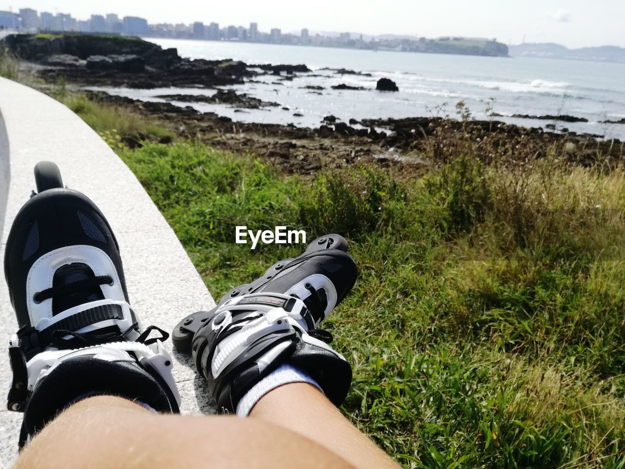 Low section of person wearing roller skating at beach