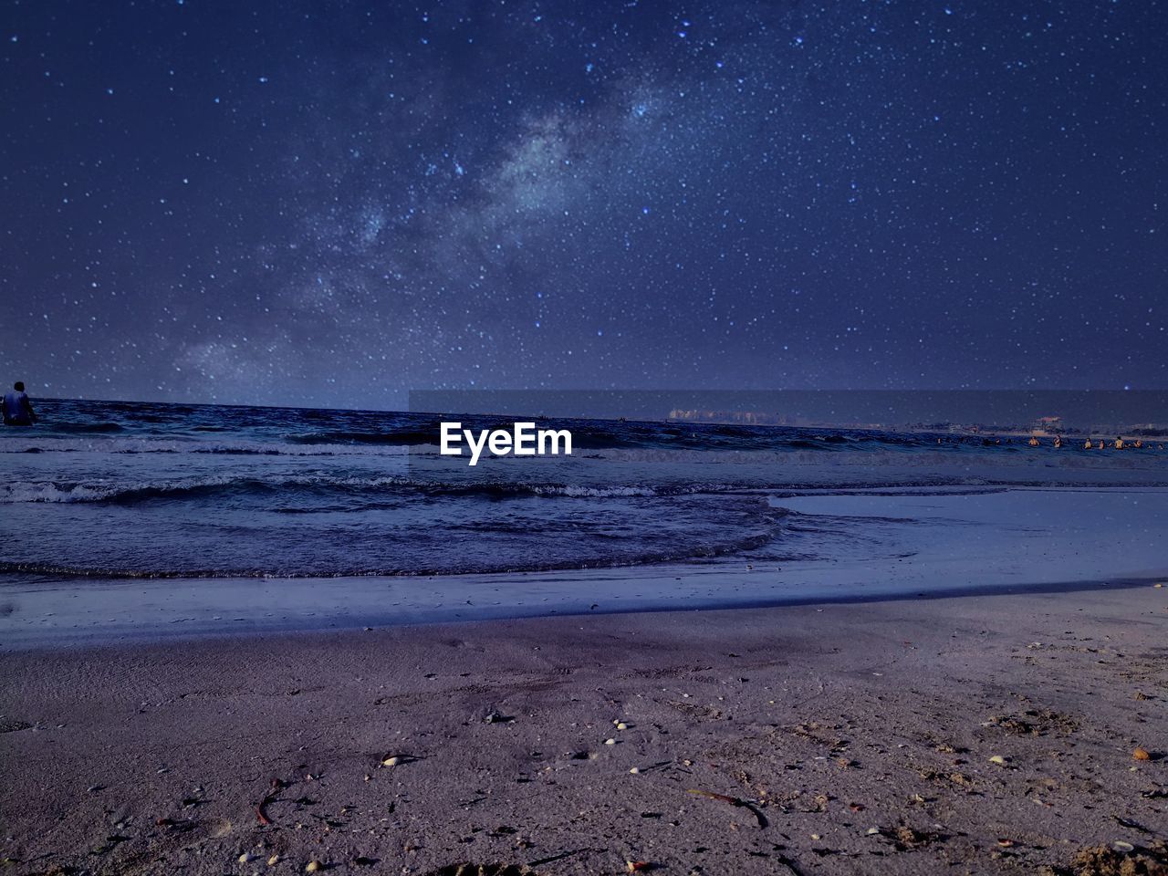 Scenic view of beach against sky at night