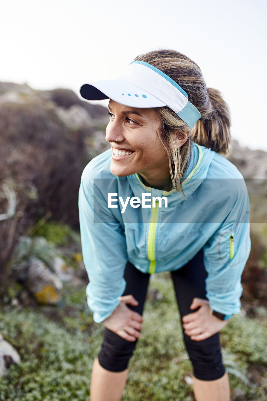 Smiling woman taking break after running