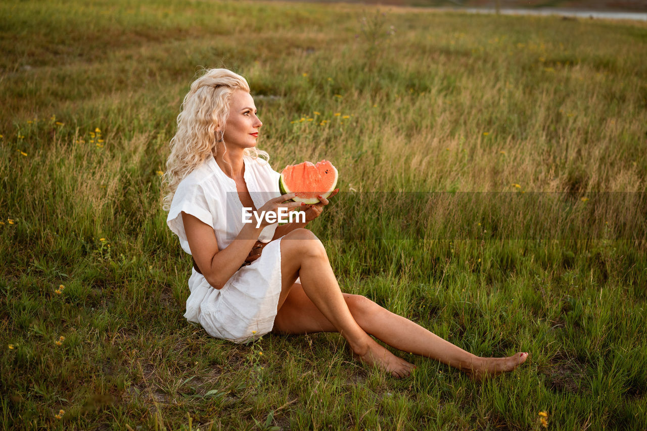 Portrait of a happy young woman enjoying and eating