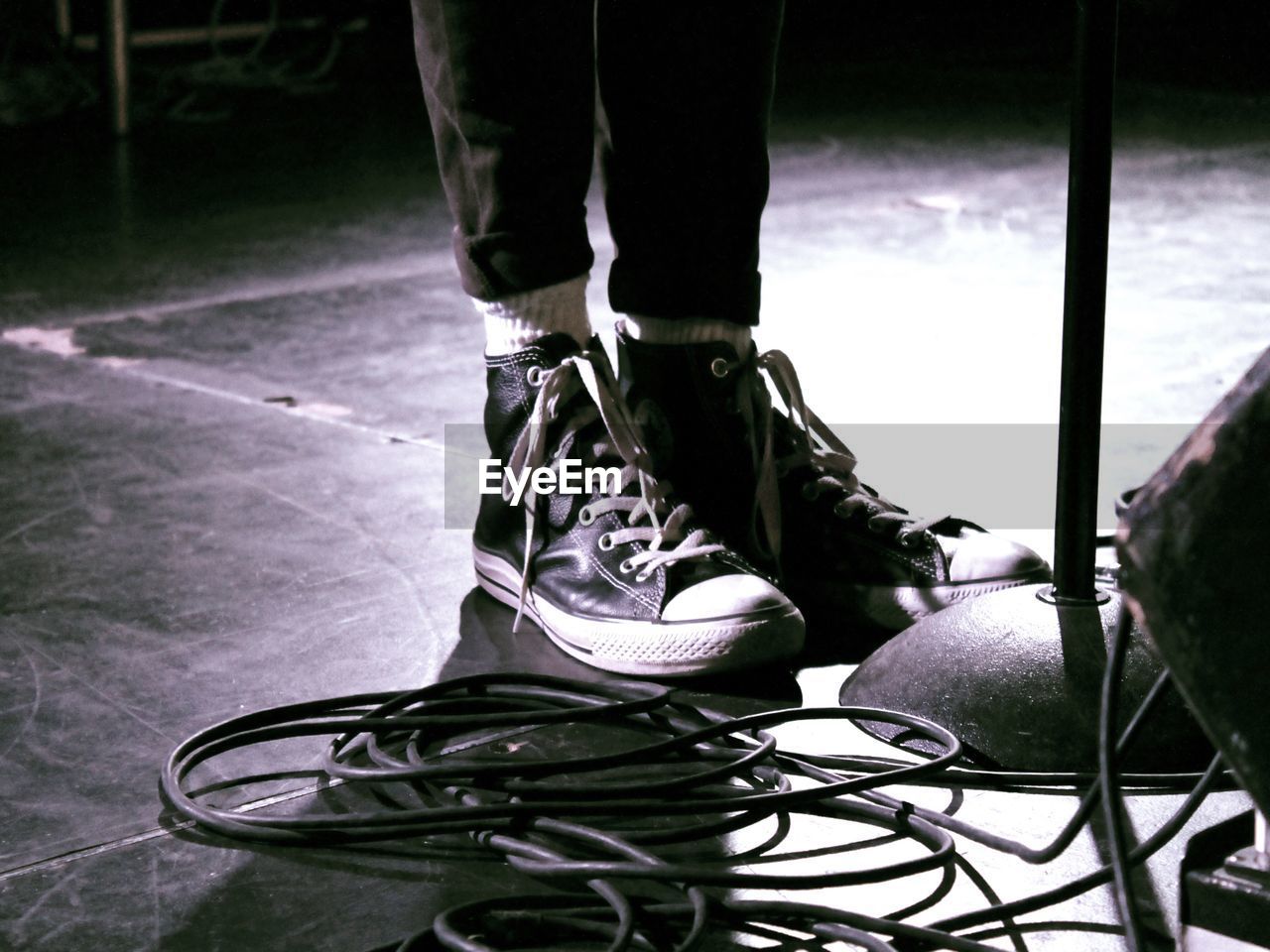 Low section of woman standing by cables on floor