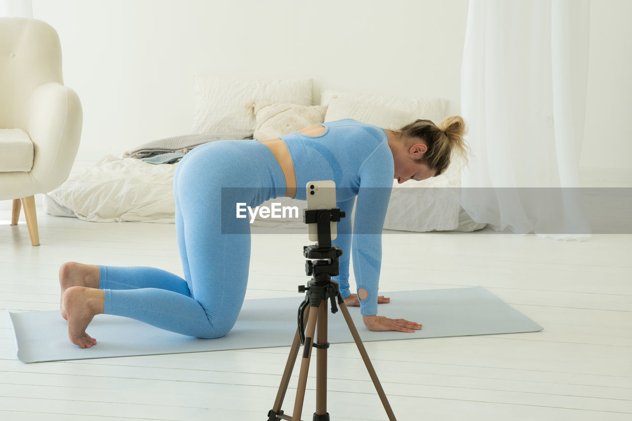 side view of woman using mobile phone while sitting on sofa at home