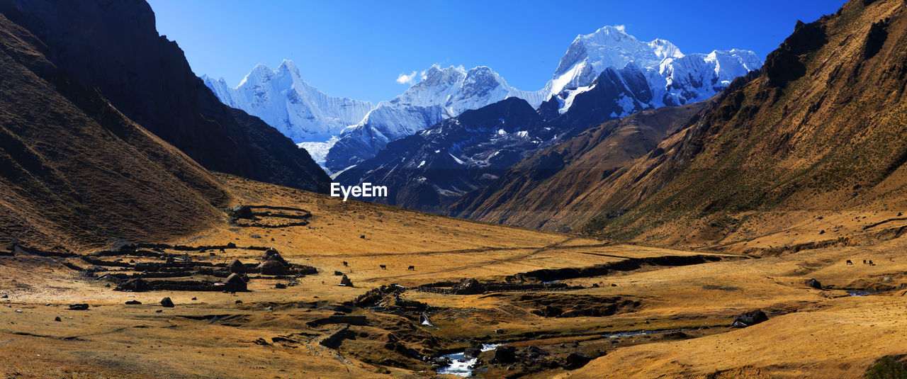 Panorama of snowy mountains and valley in the remote cordillera huayhuash circuit in peru.