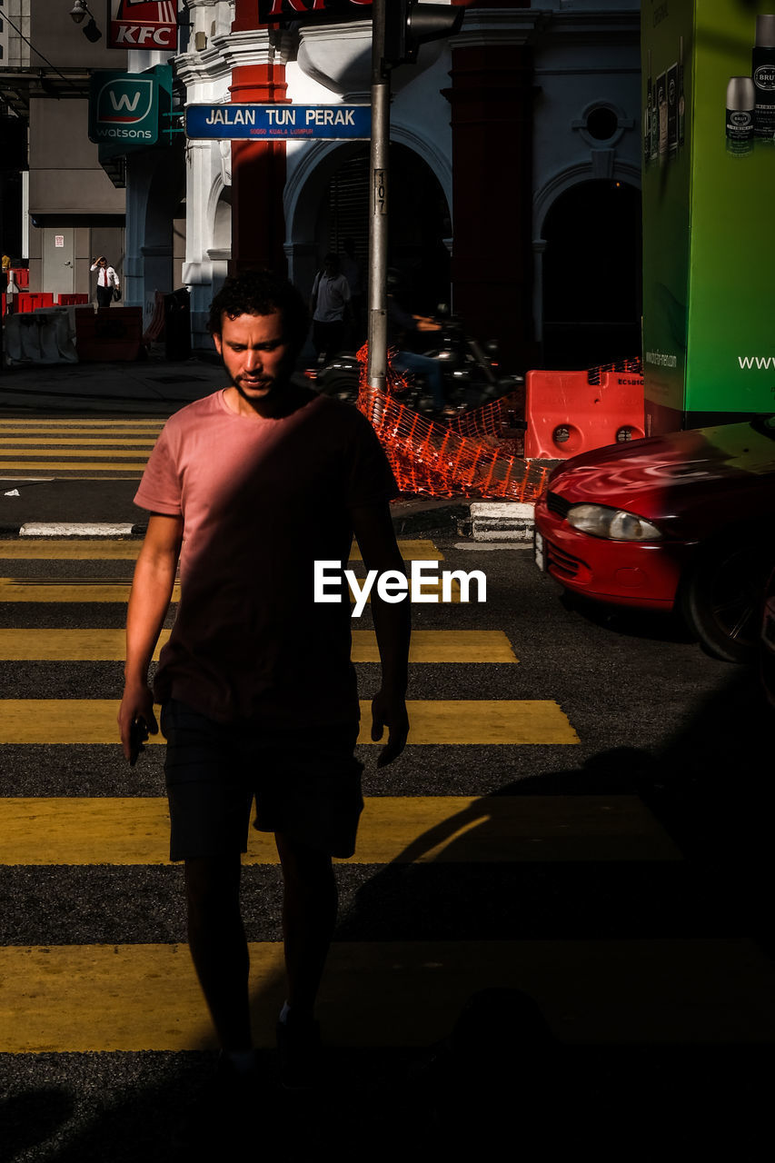 FULL LENGTH OF MAN STANDING ON ROAD