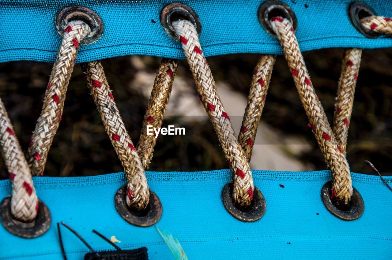 Close-up of rope tied up of blue swing