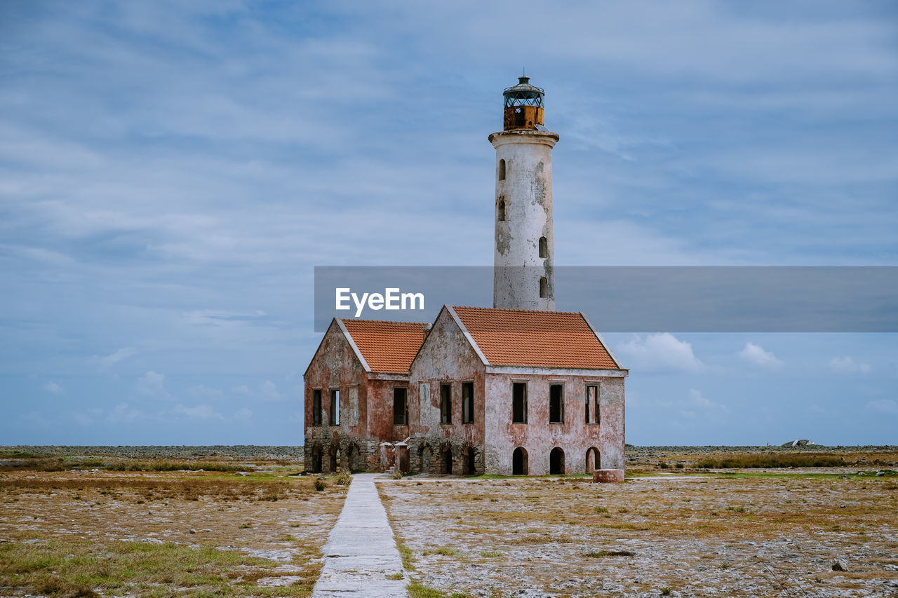 VIEW OF LIGHTHOUSE AMIDST BUILDINGS AGAINST SKY