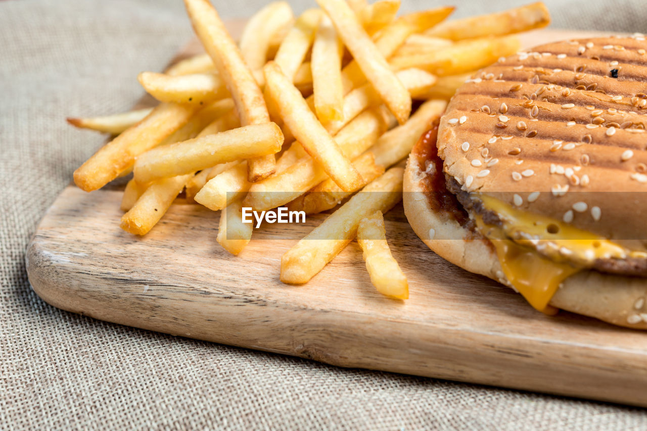 Close-up of burger with french fries on serving board