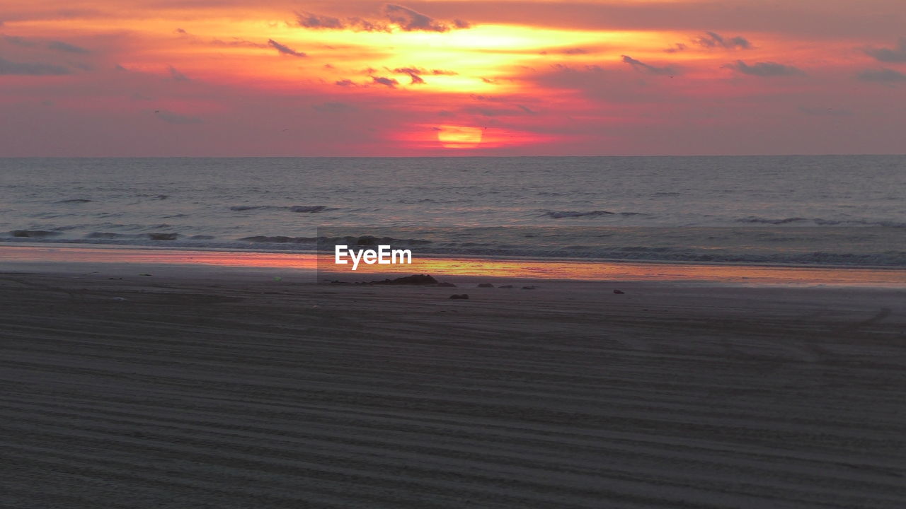 Scenic view of beach against sky during sunset