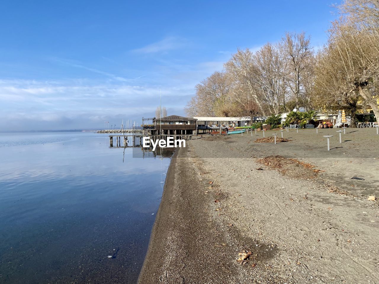 water, sky, shore, body of water, sea, nature, beach, coast, tree, land, beauty in nature, scenics - nature, day, tranquility, blue, plant, sand, tranquil scene, cloud, architecture, outdoors, no people, travel destinations, built structure, holiday, walkway, horizon, reflection, sunlight