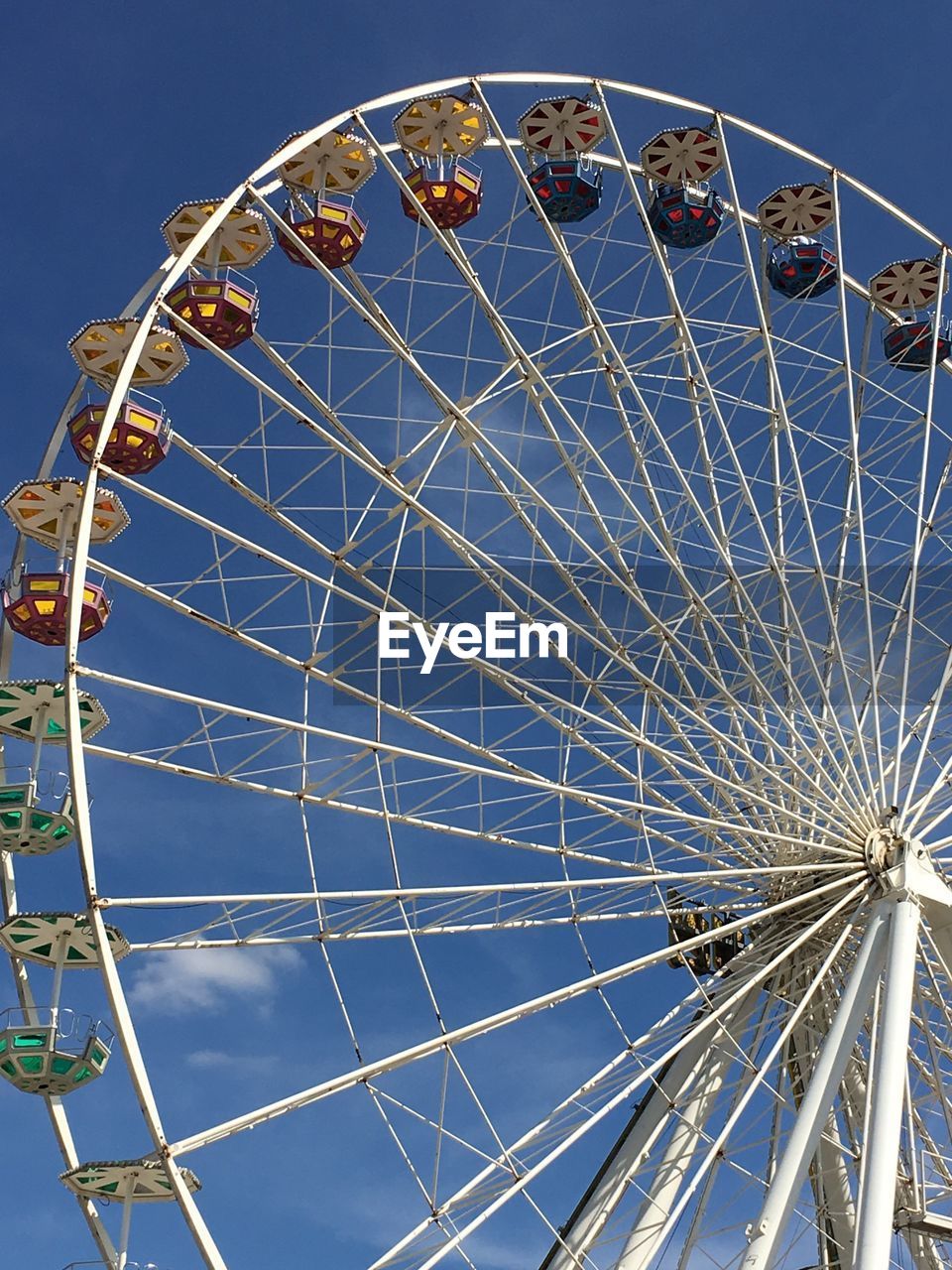 Low angle view of ferris wheel against blue sky