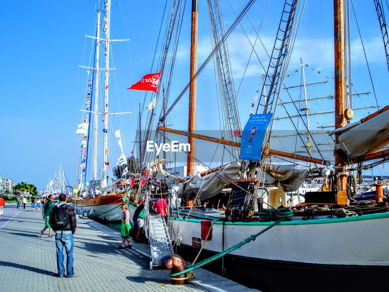 BOATS MOORED IN HARBOR AGAINST CLEAR SKY