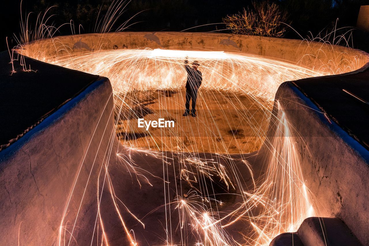 Man among light trail at night