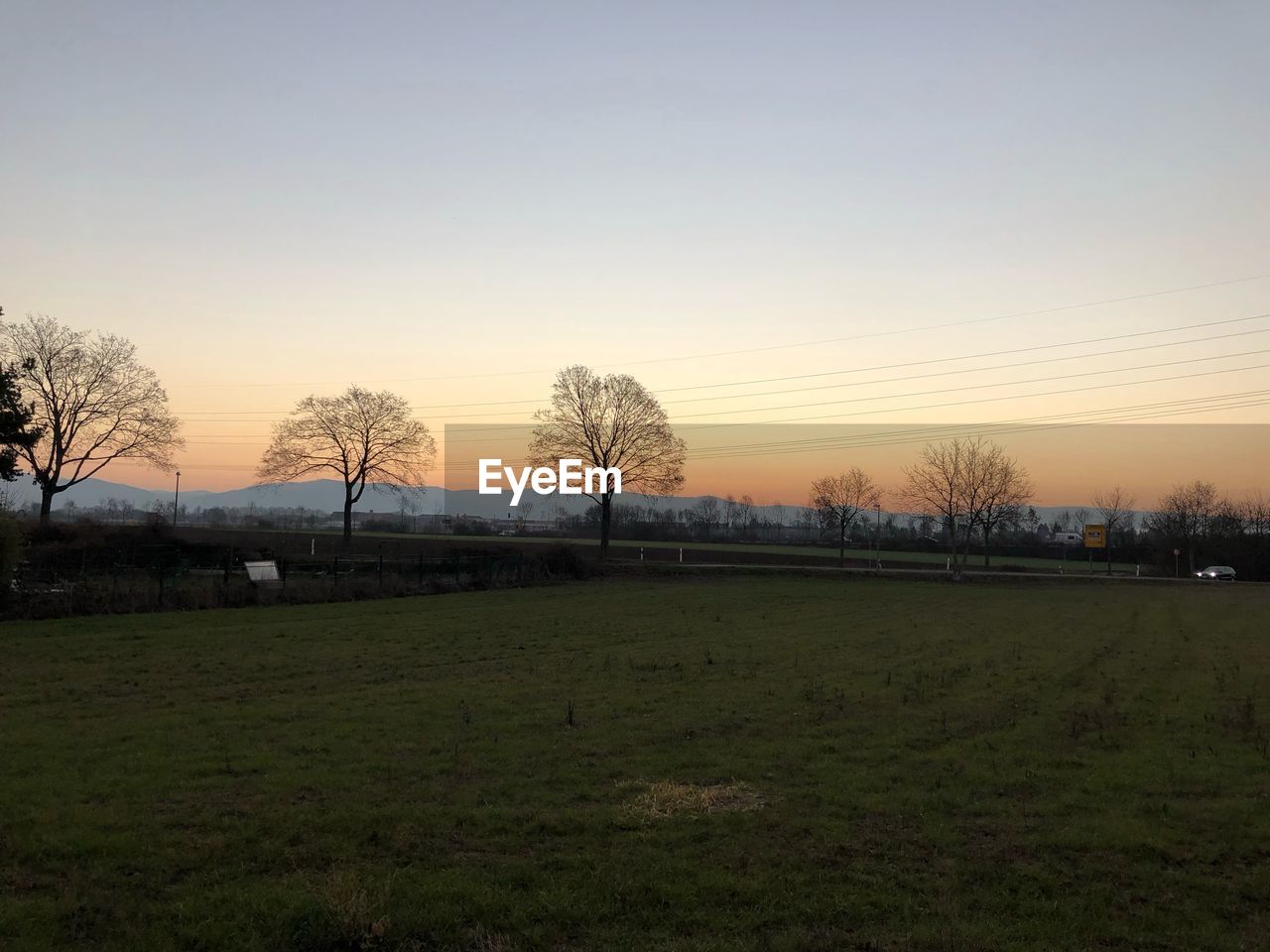 SCENIC VIEW OF FIELD AGAINST SKY AT SUNSET