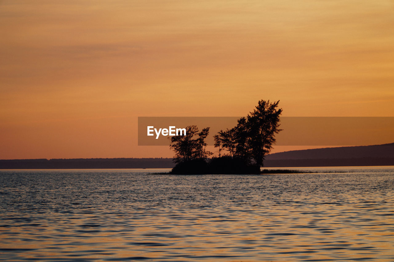 Scenic view of lake against romantic sky at sunset