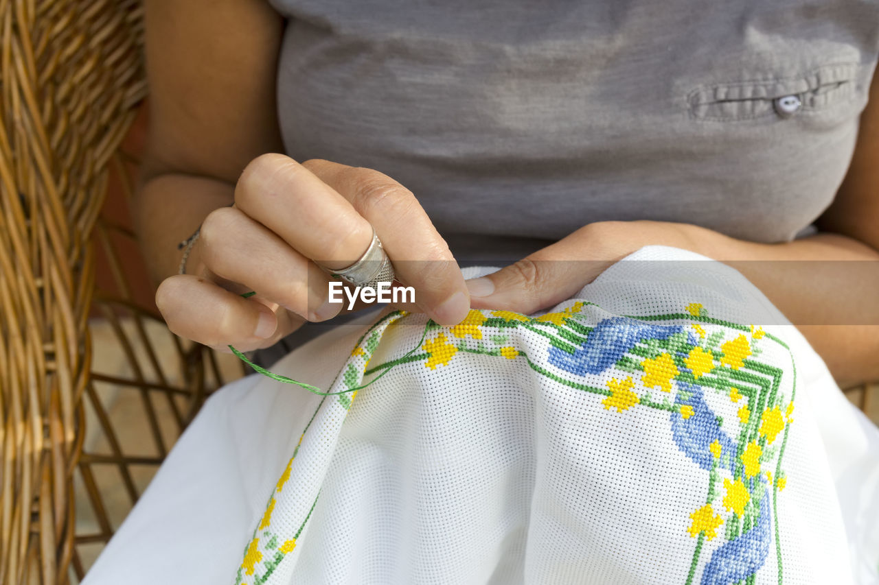 Midsection of woman embroidering on fabric