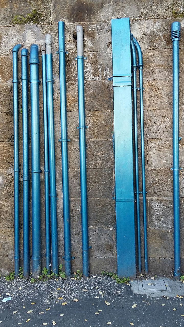 Blue pipes on stone wall