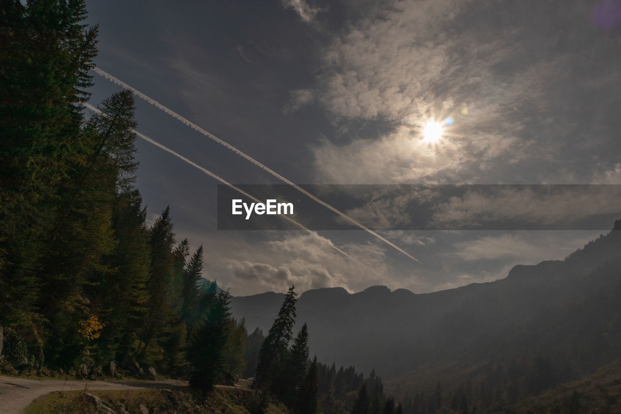 Scenic view of mountains against sky and airplane trails