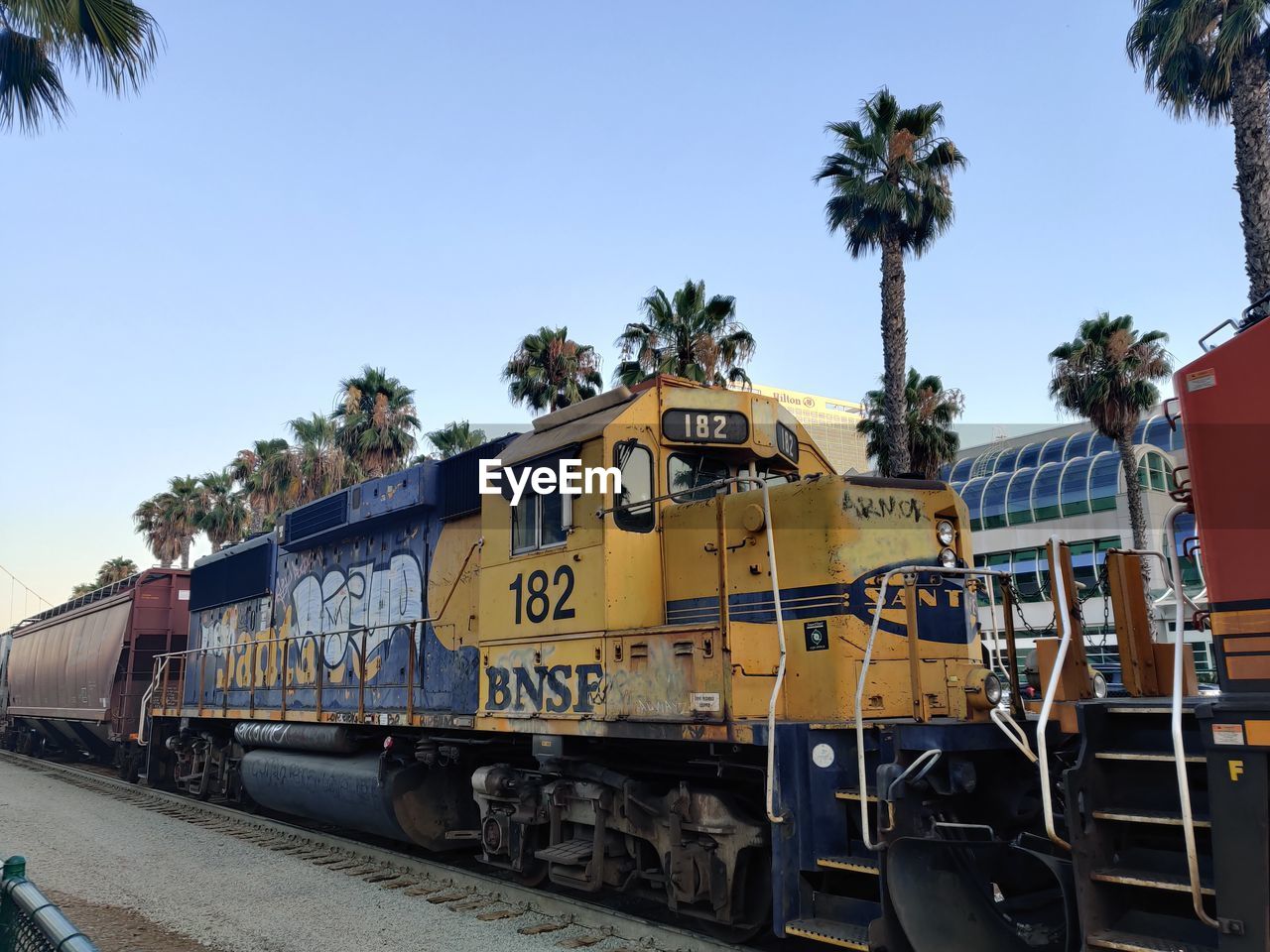 TRAIN BY RAILROAD TRACKS AGAINST SKY