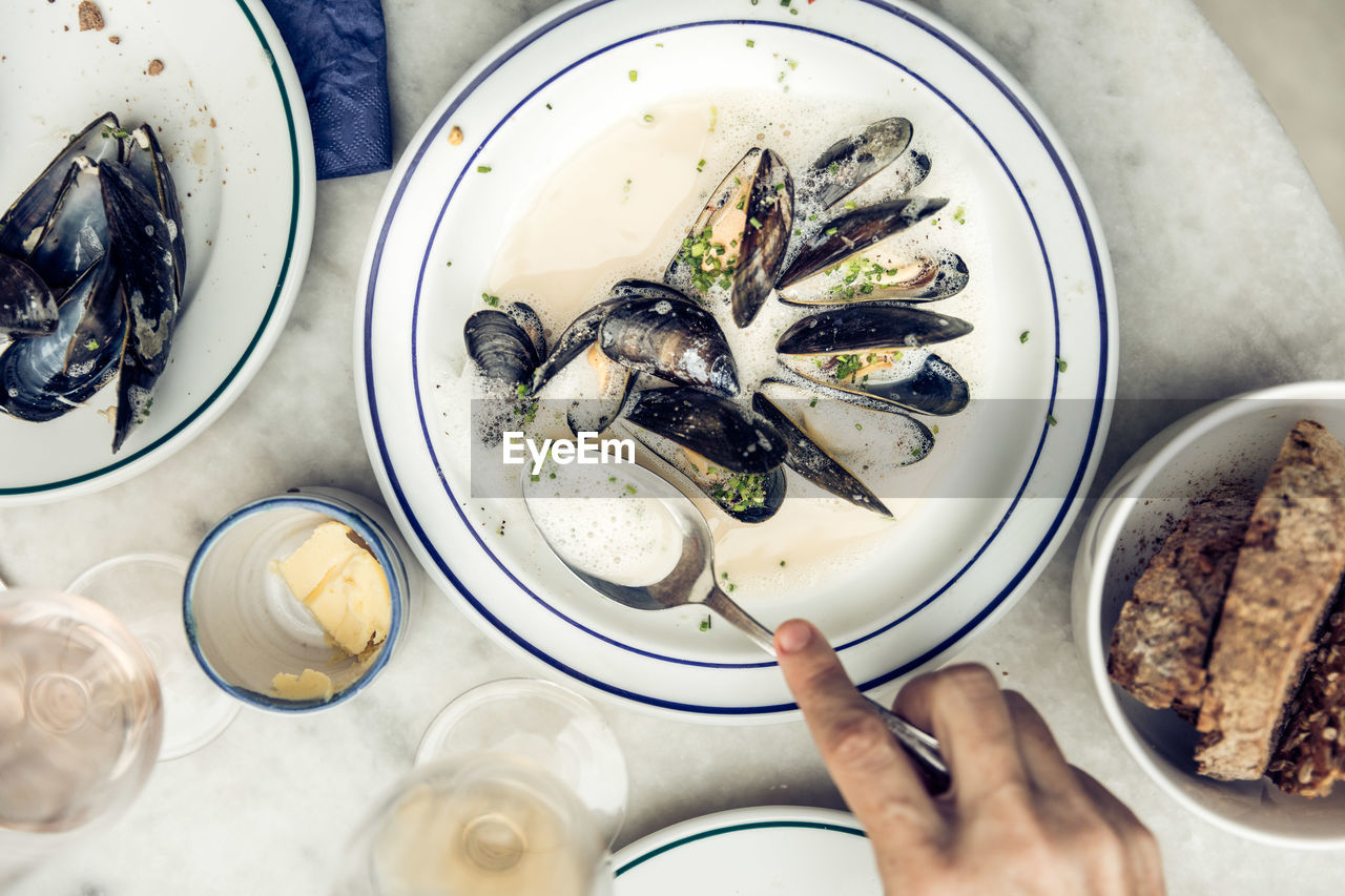 Cropped hand having clams on table