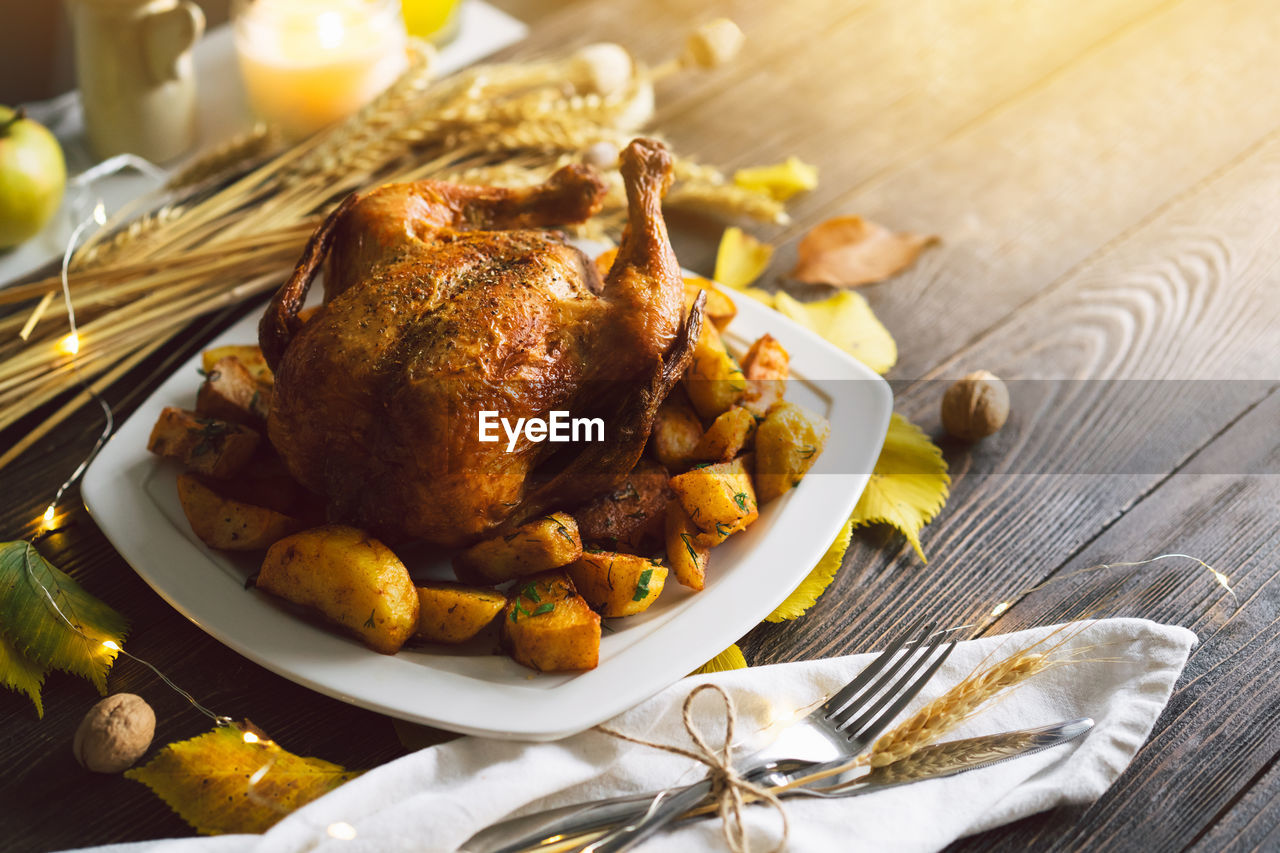 Autumn composition with leaves, ripe pumpkin and thanksgiving turkey on a dark wooden table.