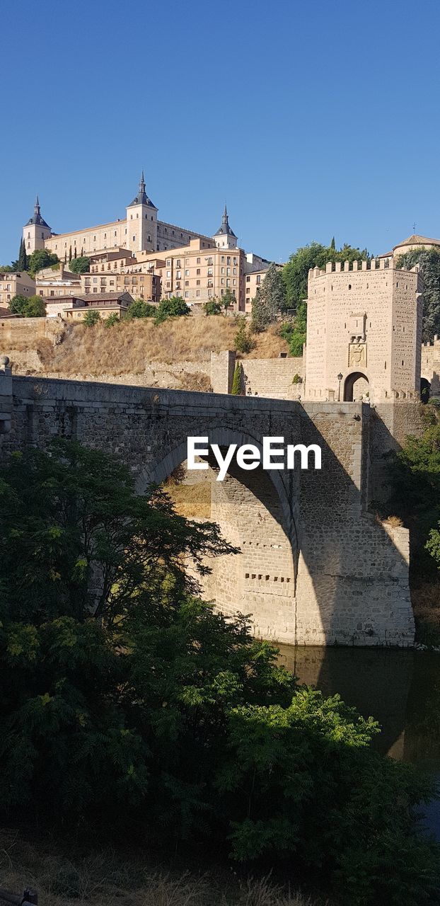 BRIDGE OVER RIVER AGAINST BUILDINGS