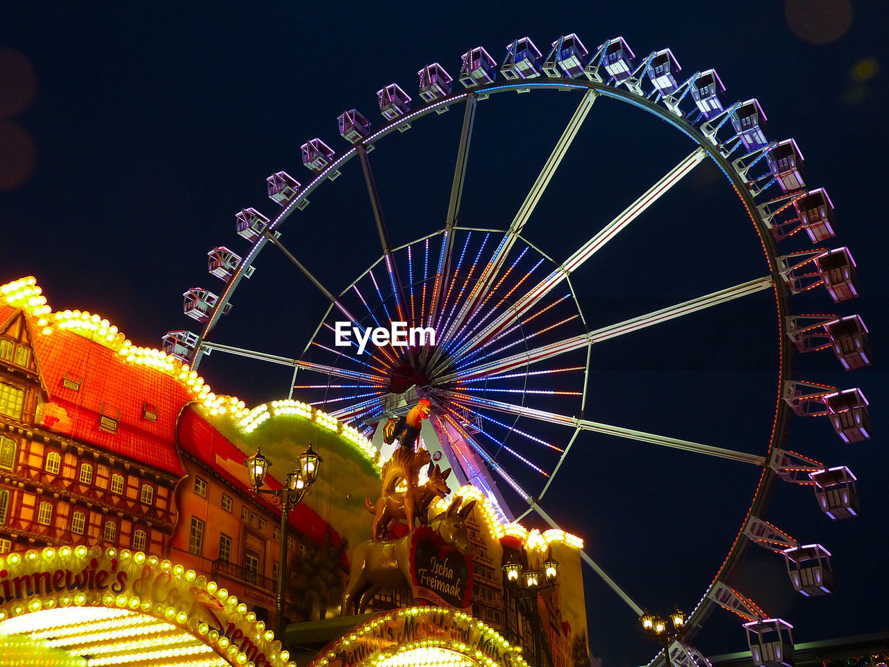 LOW ANGLE VIEW OF FERRIS WHEEL AGAINST SKY AT NIGHT