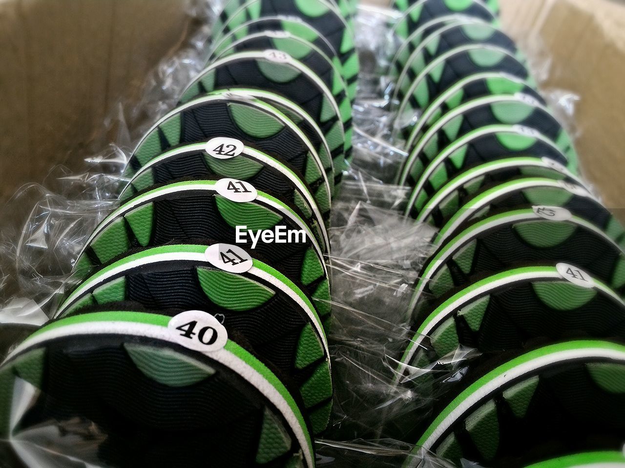 Close-up of new green and black flip-flops in cardboard box