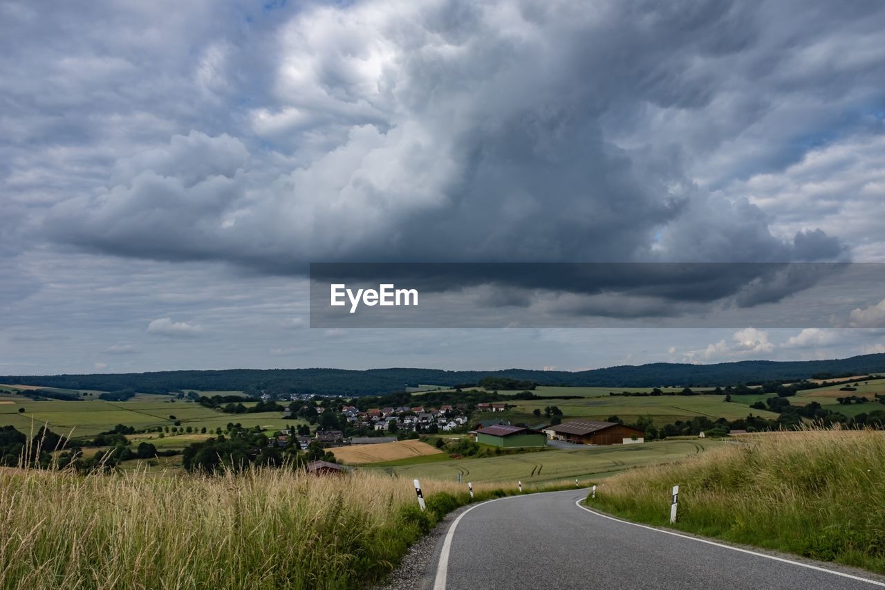 Empty road along countryside landscape