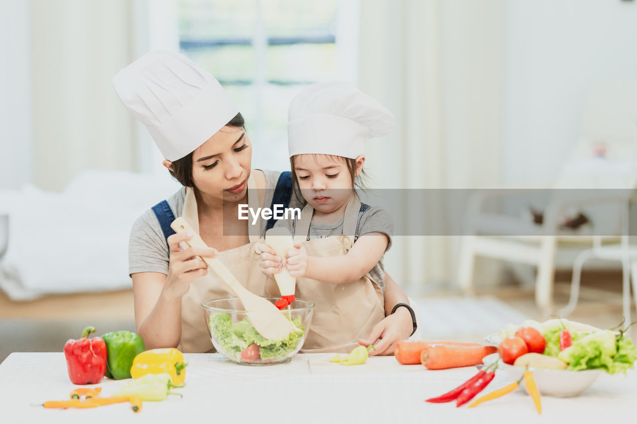 WOMEN AND VEGETABLES IN KITCHEN