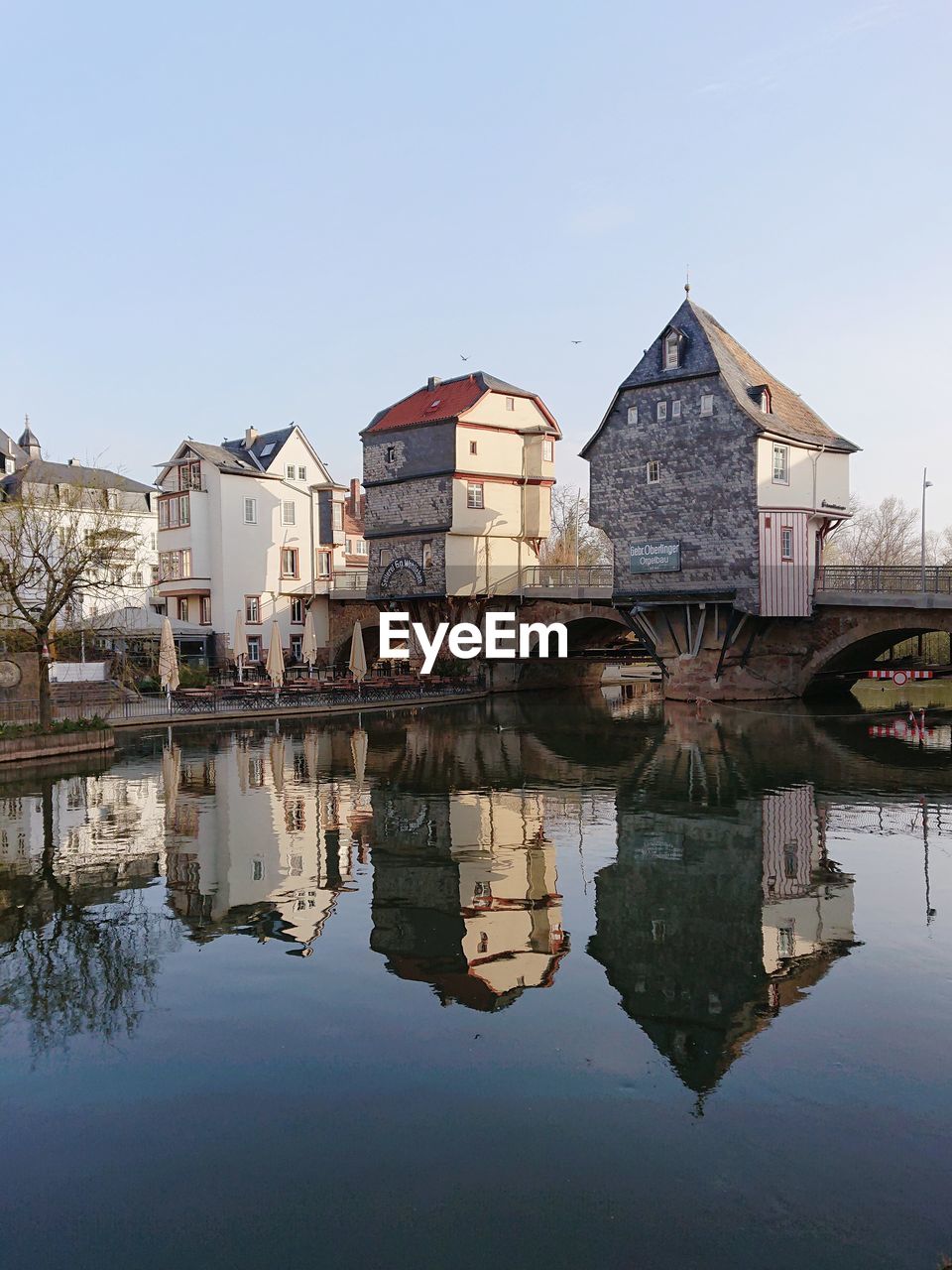 REFLECTION OF HOUSES AND BUILDINGS IN LAKE AGAINST SKY