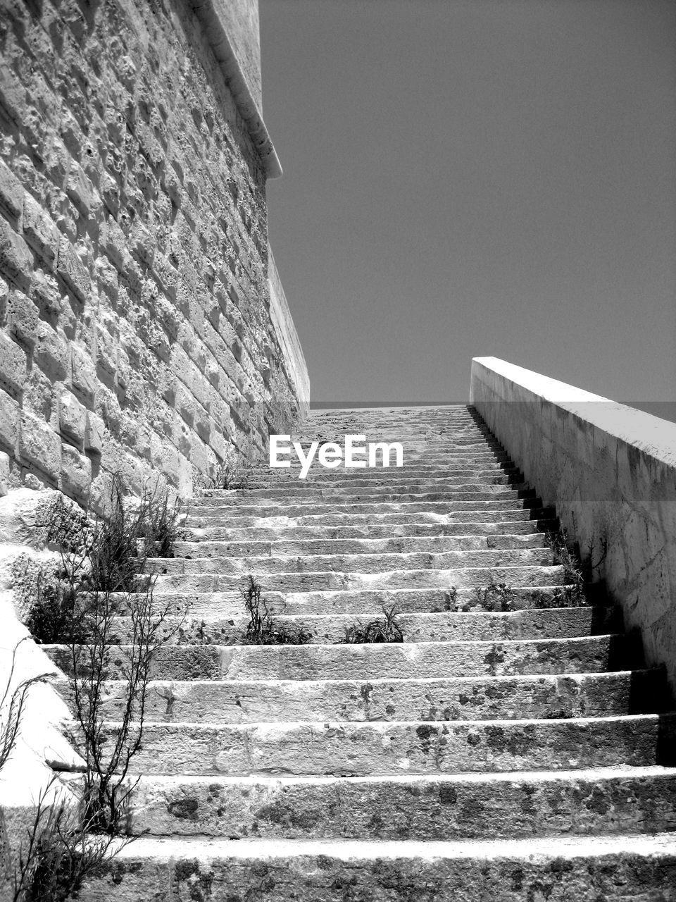 LOW ANGLE VIEW OF STAIRCASE BY BUILDING AGAINST SKY