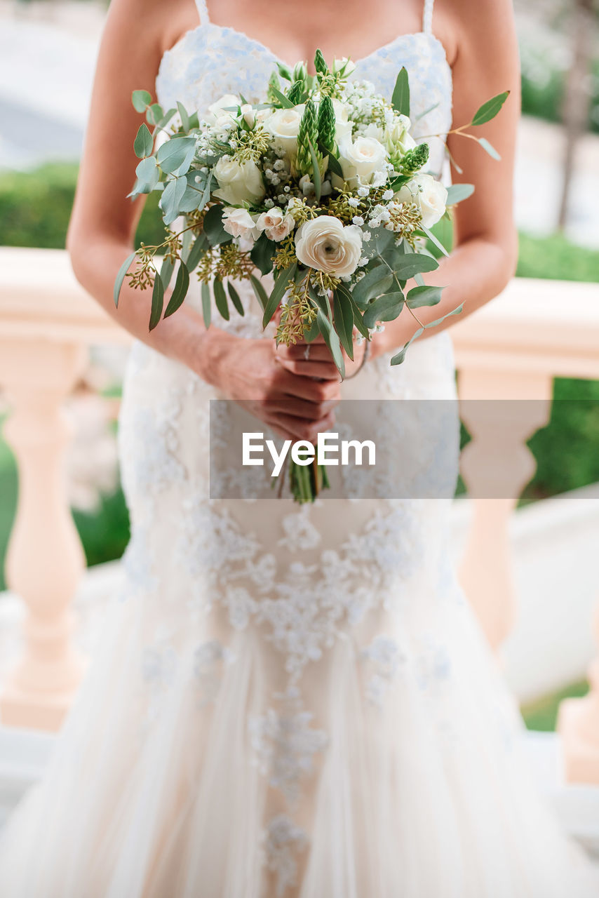 Midsection of woman holding flower bouquet