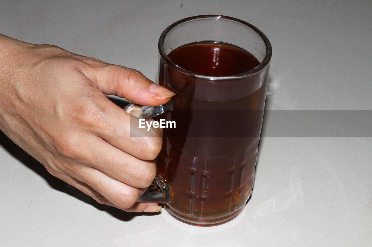 CLOSE-UP OF MAN HOLDING GLASS