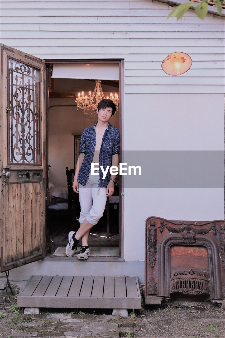 Teenage boy standing at doorway