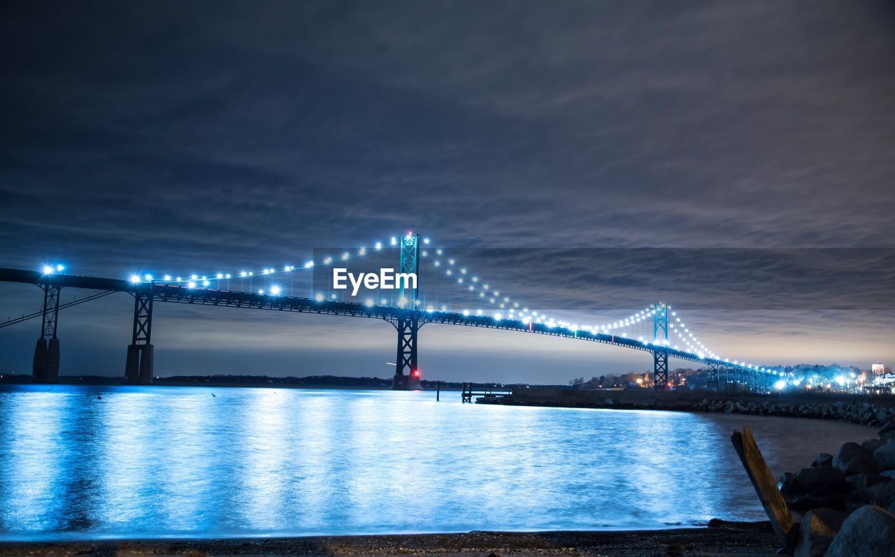 SUSPENSION BRIDGE OVER RIVER AT NIGHT