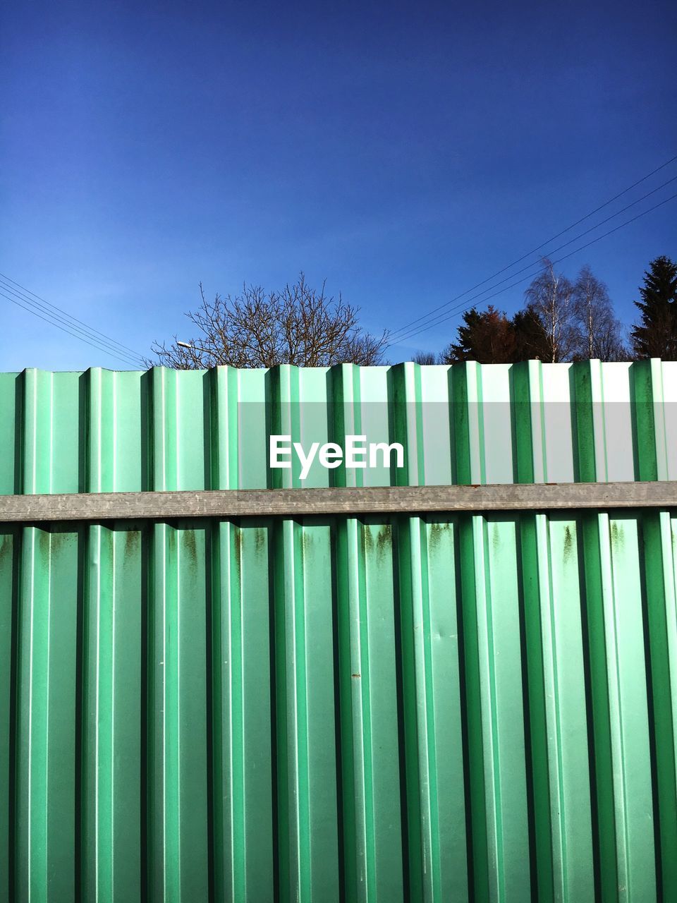 Low angle view of fence against sky