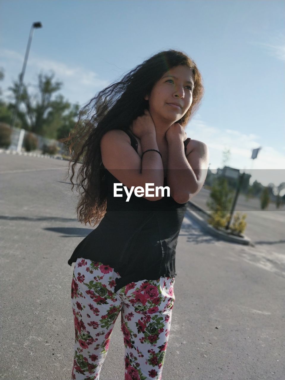 Young woman standing against sky