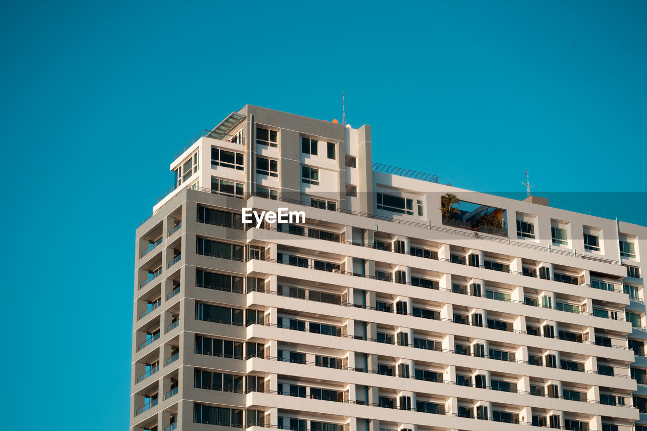 Low angle view of modern building against clear blue sky