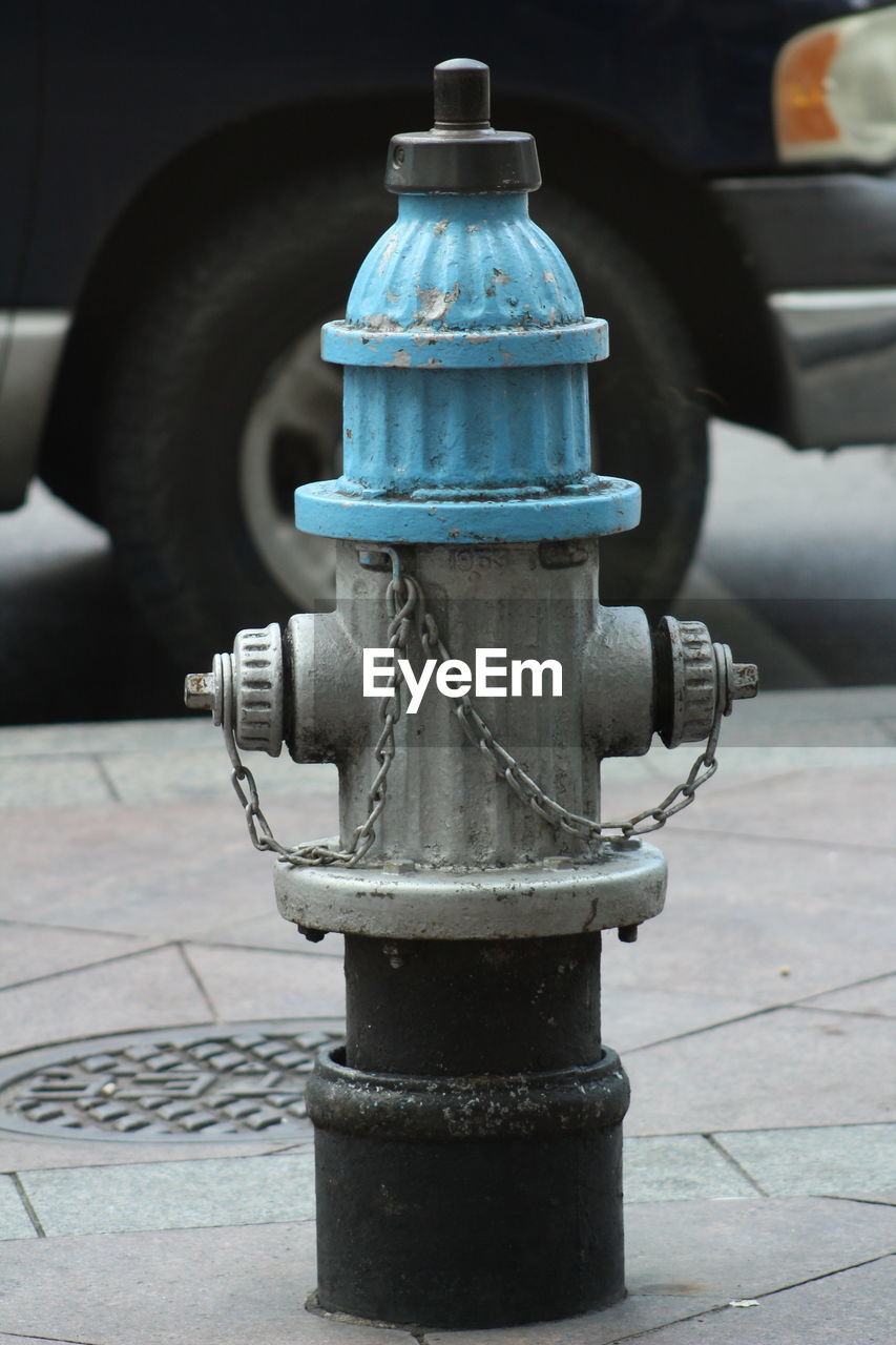 CLOSE-UP OF FIRE HYDRANT ON FOOTPATH