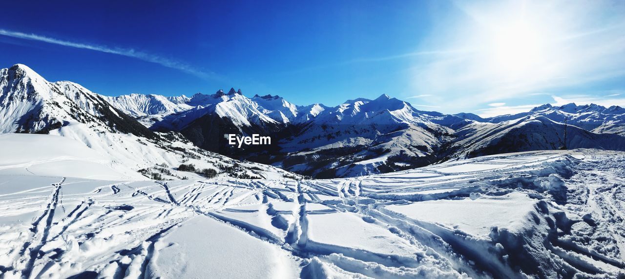 Scenic view of snowcapped mountains against blue sky